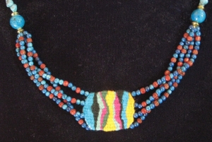 Loom woven pendant with dyed fossil beads